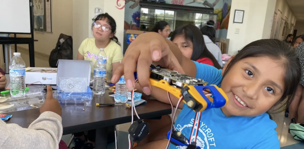 Girl at Latinas Leading Tomorrow holds toy.